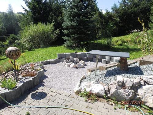 a garden with a bench and some rocks at Chalupa pod sjezdovkou in Chvaleč
