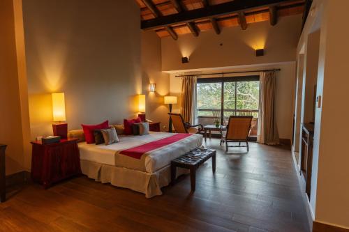 a bedroom with a large bed with red pillows at Loi Suites Iguazu Hotel in Puerto Iguazú