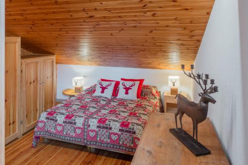a bedroom with a bed and a wooden ceiling at Ciasa de Sèn Jan in Pozza di Fassa