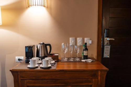 a table with cups and glasses and a bottle of wine at Loi Suites Iguazu Hotel in Puerto Iguazú