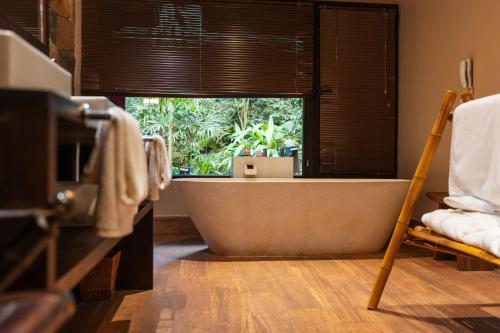 a bath tub in a bathroom with a window at Loi Suites Iguazu Hotel in Puerto Iguazú