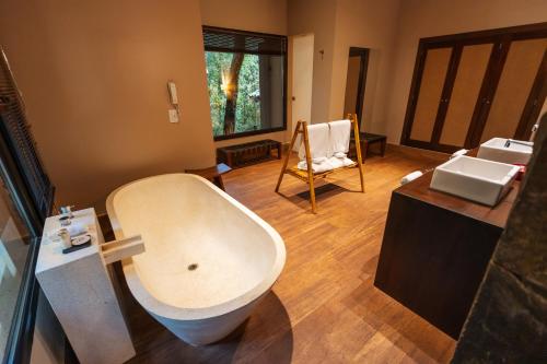 a bathroom with a white bath tub and a sink at Loi Suites Iguazu Hotel in Puerto Iguazú