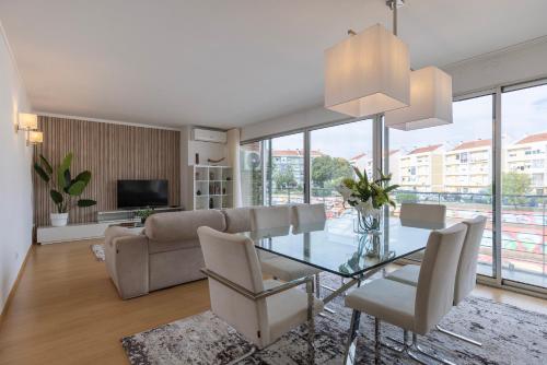 a living room with a glass table and a couch at Charm 3BDR Apartment W/Balcony by LovelyStay in Lisbon