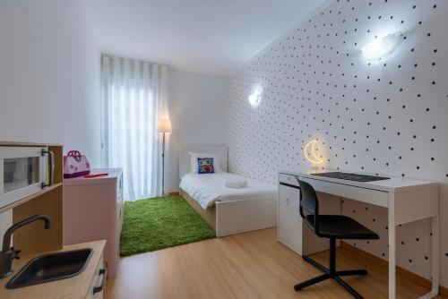 a small bedroom with a desk and a bed at Charm 3BDR Apartment W/Balcony by LovelyStay in Lisbon