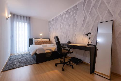 a bedroom with a bed and a desk and a mirror at Charm 3BDR Apartment W/Balcony by LovelyStay in Lisbon