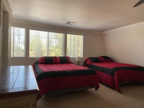 um quarto com 2 camas com lençóis vermelhos e janelas em Wondrous Stays em Temecula
