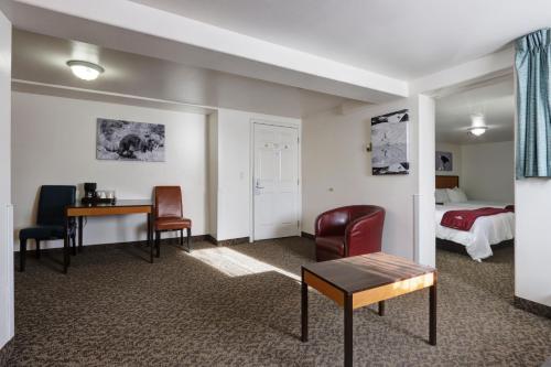 a hotel room with a bed and a table and chairs at Puffin Inn in Anchorage