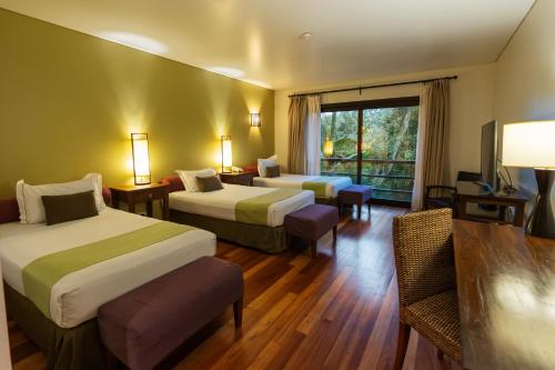 a hotel room with two beds and a window at Loi Suites Iguazu Hotel in Puerto Iguazú