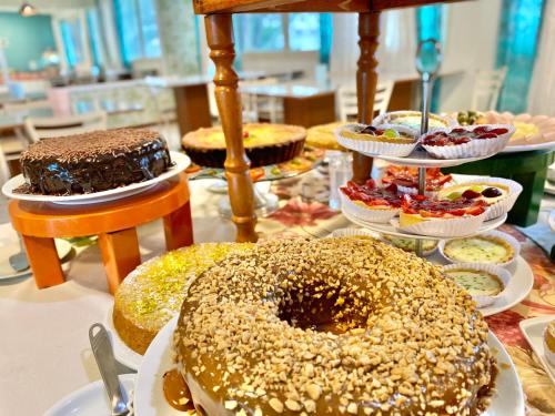 a table topped with different types of cakes and desserts at Morada do Mar Hotel in Bombinhas