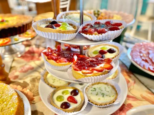 a tiered display of cakes and pies on a table at Morada do Mar Hotel in Bombinhas