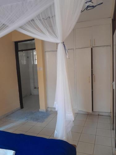 a bed with a white canopy in a room at REHOBOTH'S APARTMENTS in Kisumu