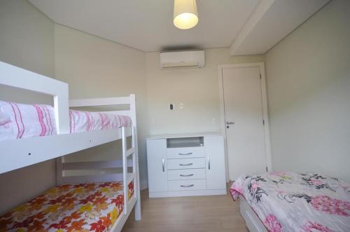 1 dormitorio con 2 literas y escritorio en 1032 - Apartamento para locação no centro de Bombinhas - Residencial Boulervard - 210, en Bombinhas