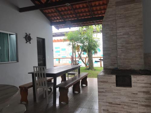 a wooden table and bench in a room at Happy Guest House in Navegantes