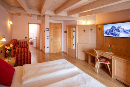 a living room with a couch and a television at B&B Casa Agostini in Fai della Paganella