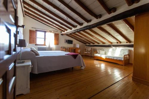a large bedroom with a large bed and a couch at El Jardín del Laurel in Candelario