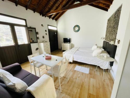 a living room with a bed and a table at Finca Santa Catalina in Hermigua