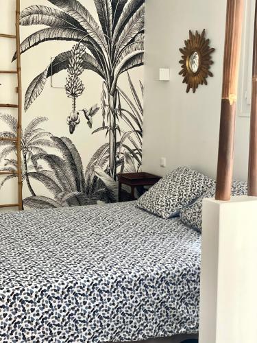 een slaapkamer met een bed en een muurschildering van planten bij Les Pinsons studio in La Ciotat