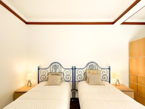 - 2 lits dans une chambre aux murs blancs dans l'établissement Quinta do Cutato - Beatriz Guest House - A2, à Santo Estêvão