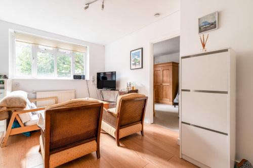 a living room with a table and a refrigerator at Gorgeous Putney Flat in London