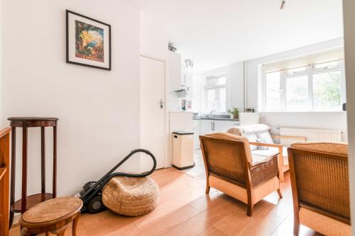 a living room with a table and chairs and a kitchen at Gorgeous Putney Flat in London