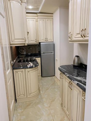 a kitchen with white cabinets and a refrigerator at home in central city in Yerevan