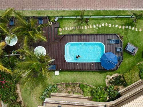 an overhead view of a pool in a yard with palm trees at Morada do Mar Hotel in Bombinhas
