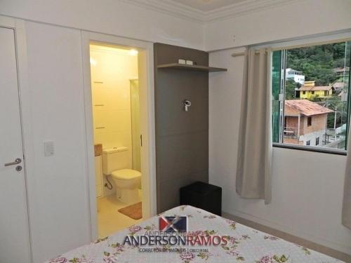 1 dormitorio con cama, aseo y ventana en 1055 - Apartamento para locação em Bombinhas - Residencial Atalanta Apto 204 B, en Bombinhas