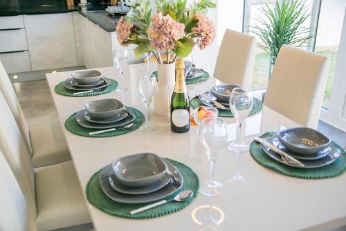 a table with plates and glasses and a bottle of wine at Fern Place Villa - Grampian Lettings Ltd 