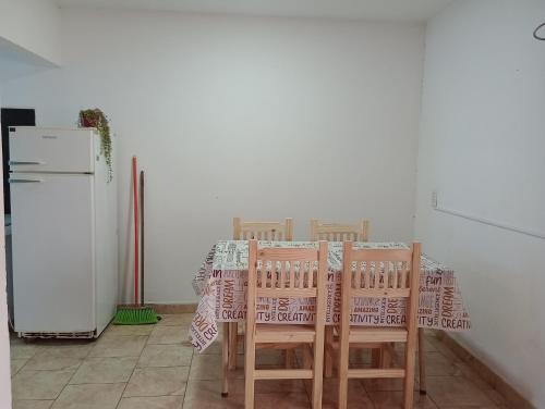 een keuken met een tafel en stoelen en een koelkast bij casa franchi in Las Flores