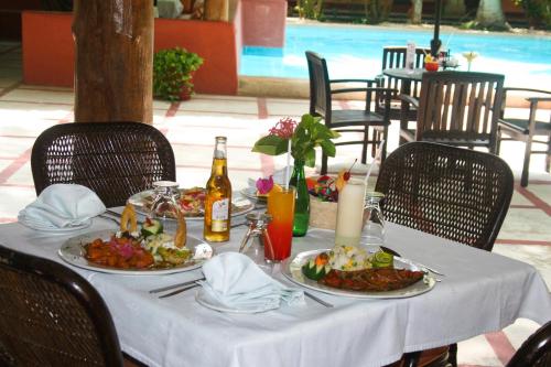 a table with plates of food and a bottle of wine at Villas Arqueologicas Chichen Itza in Chichén-Itzá