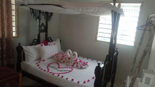 Manama Suite في لامو: غرفة نوم عليها سرير بقلوب