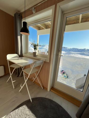 Room in Tromsø, Kvaløya في ترومسو: طاولة وكراسي في غرفة مع نافذة