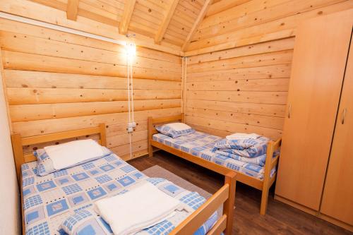 1 dormitorio con 2 camas en una cabaña de madera en Rafting Center "TARA-RAFT", en Bastasi