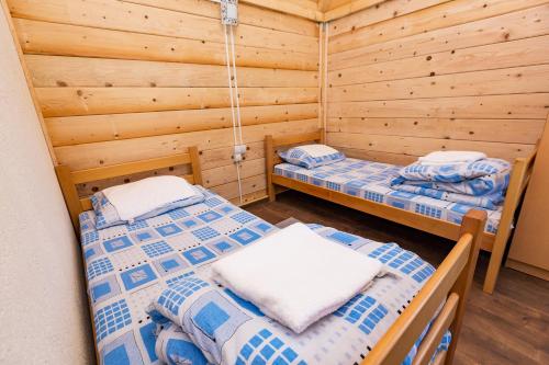 Habitación con 2 camas en una cabaña de madera en Rafting Center "TARA-RAFT", en Bastasi