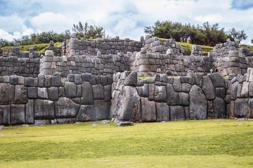 un grande muro di pietra in un campo erboso di traverse peru a Cuzco