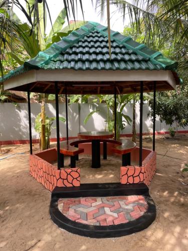 a gazebo with a picnic table in a garden at MSV VILLA RÉSIDENCE HOME in Batticaloa