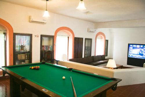 a living room with a pool table and a tv at Villas Arqueologicas Chichen Itza in Chichén-Itzá
