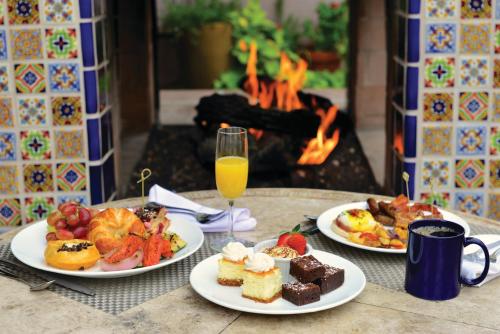 a table with two plates of food and a glass of orange juice at Lodge On The Desert in Tucson