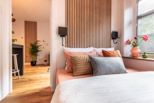 a bedroom with a bed with pillows and a window at Boutique Studio Amsterdam near RAI and De Pijp in Amsterdam