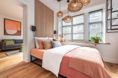 a bedroom with a bed and two windows at Boutique Studio Amsterdam near RAI and De Pijp in Amsterdam