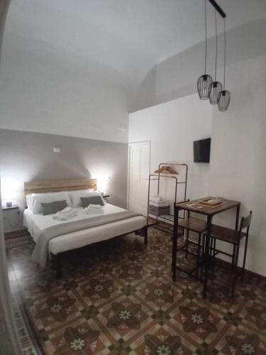 a bedroom with a bed and a table and a chair at AREMU in Lecce
