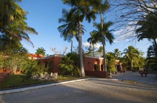 a street in front of a house with palm trees at Villas Arqueologicas Chichen Itza in Chichén-Itzá