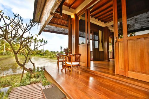 a porch of a house with a table and chairs at Bliss Ubud Spa Resort in Ubud