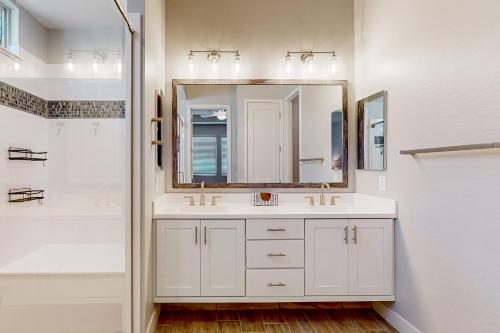 a white bathroom with a sink and a mirror at Desert Diamond in Gilbert