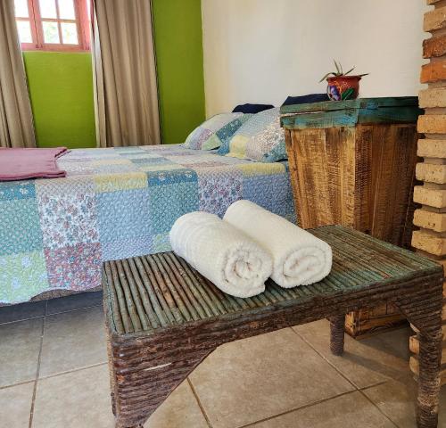 a bedroom with two beds and towels on a bench at Sítio SPA Céu De Verdade , Praia de Barra Nova , Ceará in Cascavel