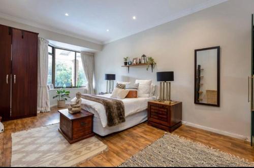 1 dormitorio con 1 cama grande y espejo en MIGJOS VILLA, en Johannesburgo