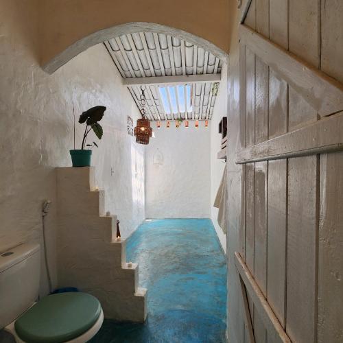 a hallway with blue flooring in a bathroom with a toilet at Sítio SPA Céu De Verdade , Praia de Barra Nova , Ceará in Cascavel