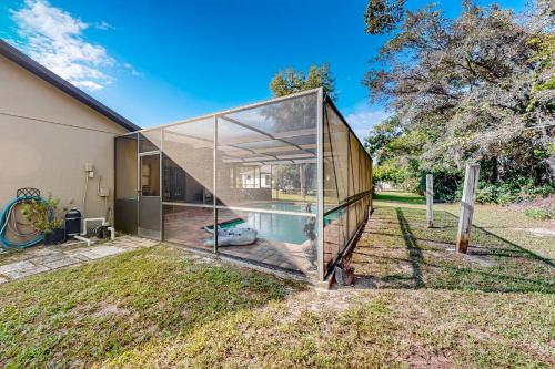 a glass house with a swimming pool in the yard at Solar Retreat in Spring Hill