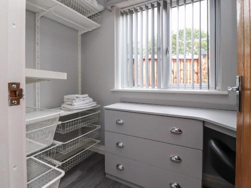 a walk in closet with a dresser and a window at Damson Cottage in Poulton le Fylde