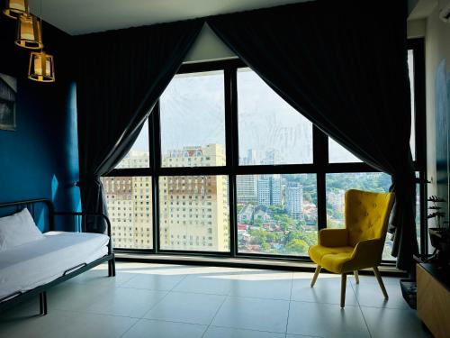 a bedroom with a bed and a chair and a large window at Urban Suite Cozy Family Homestay at Georgetown by URBAN STAYCATION HENG LOD in Jelutong
